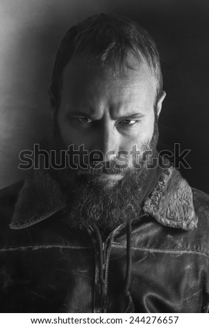 Black and white portrait of an angry bearded man.