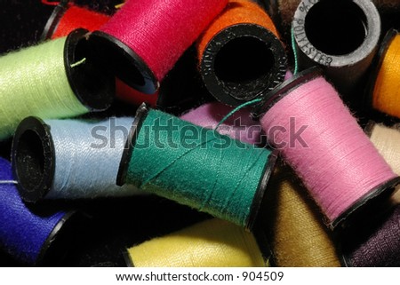 A closeup of a colorful pile of assorted spools of thread
