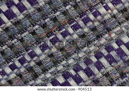 Extreme close-up of the weave of a man\'s tweed-style tie, revealing the secret of the fabric\'s subtle shades