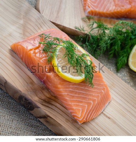 Fresh salmon on cedar plank with dill and lemon.