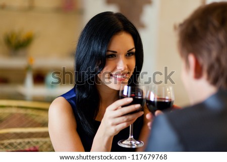 Young happy couple romantic date drink glass of red wine at restaurant celebrating valentine day Young happy couple romantic date drink glass of red wine at restaurant celebrating valentine day