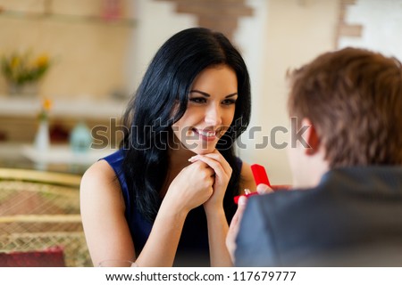 marriage proposal, man give ring to his girl, young happy couple romantic date at restaurant, celebrating valentine day