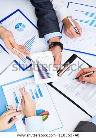 business people working touch screen, businessmen hold touchpad in hand working in team discuss report using tablet pc computer discuss financial chart data, Close up top angle view work place desk
