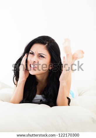 angry disappointed woman phone call lying on sofa in living room, at home, annoyed upset girl talking using cellphone