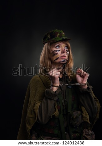 army girl in handcuffs, soldier woman in a military uniform over black background