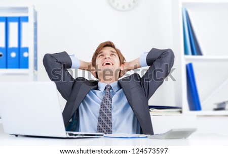 Relaxed young business man happy smile sitting at the desk, handsome businessman relaxing hold hand on head look up