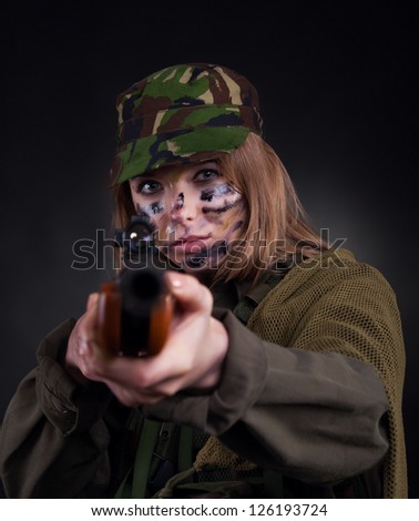 Beautiful army girl, soldier woman with rifle military uniform over black background