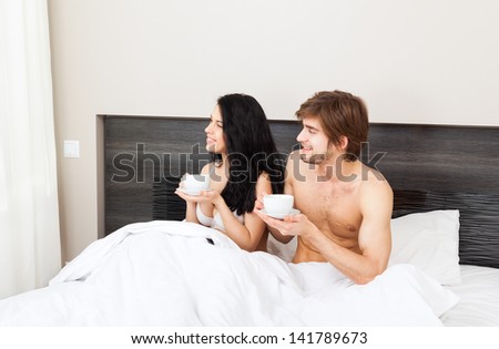 young couple drink coffee in bed, happy smile woman man lovers looking at window dream think, love romantic valentine day morning pondering concept
