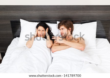 unhappy couple lying in a bed, having conflict problem cheat separate, aggressive man scream on woman, upset sad negative emotions concept