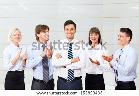 Business people applauding congratulating colleague, boss, team leader success, businesspeople group smile, at modern office