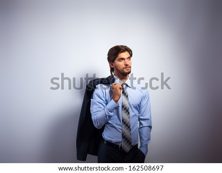 Fashion business man, Handsome male model blue shirt and tie suit look side to copy space, young businessman over gray background