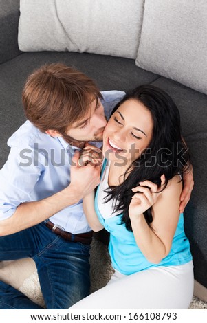 young couple kiss on couch, romantic love happy excited smile, lovely man kissing woman embrace on the sofa, lover