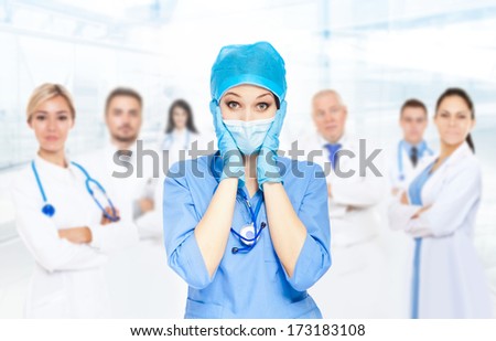 Medical doctor serious team negative emotions problem, woman with stethoscope hold hand head stress, nurse wear blue surgery suit gloves mask cap in hospital over people group background