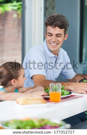 Father and daughter lunch together, happy smile eating breaksfast, sitting at home dinner table