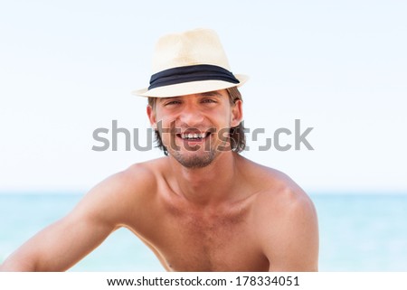 man smile on beach summer vacation, Handsome young male wear hat, sun tanned body, guy over sea blue sky, concept ocean holiday travel