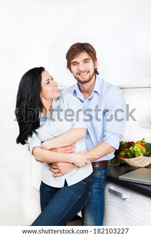 couple at their kitchen home happy smile cooking, young family man and woman