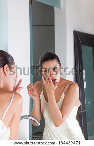 Beautiful woman looking eyes, cosmetics beauty face mirror in bathroom, skin health care