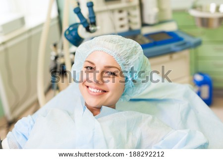 beautiful patient smile lying on bed in surgery room hospital