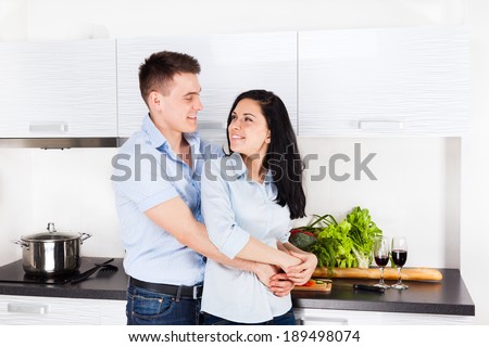 couple at their kitchen home happy smile cooking, young family man and woman