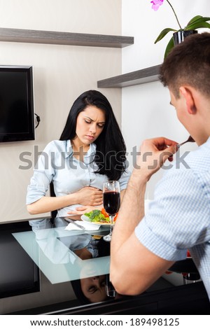 stomach ache, woman hold hand belly pain, couple dinner sitting at table, girl eat problem food at home or restaurant couple , sitting table dinner, home or restaurant