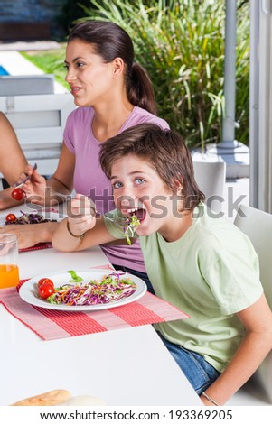mother and son lunch, eating happy smile, pretty woman with little boy sitting at home dinner table restaurant or cafe