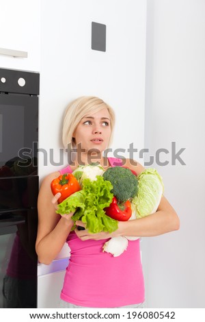 unhappy woman hold raw fresh vegetables refrigerator, sad negative emotion diet healthy organic vitamin food concept, young girl looking copy space at home modern kitchen