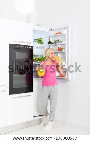 young woman drink orange juice hold glass refrigerator open door, pretty girl smile dieting healthy food vegetables and fruits, modern kitchen natural organic fruit