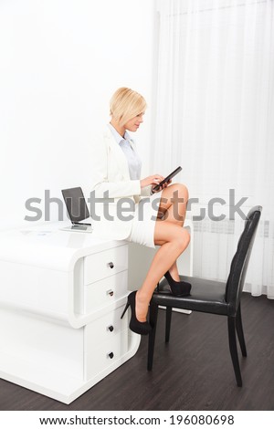 business woman using tablet sitting on desk bright modern office, businesswoman full length workplace