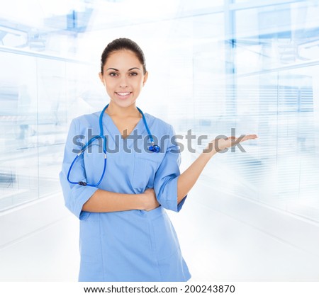 nurse doctor woman smile with stethoscope, hold hand showing open palm empty copy space, concept advertisement product, wear blue surgery medical suit in hospital