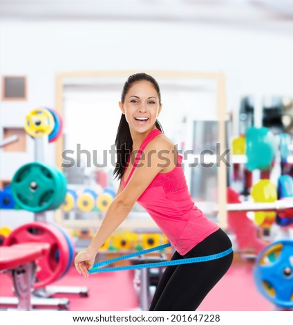 sport fitness woman in gym excited smile measure hips ass with tape, young healthy perfect slim figure, concept of diet, weight loss cellulite