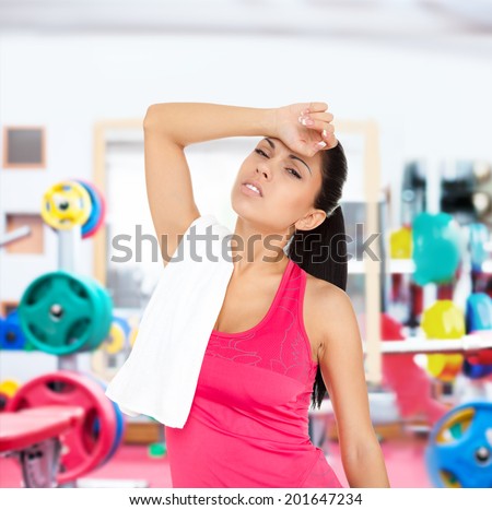 Sport fitness woman head ache in gym, young girl hold head hand suffering from headache, tired workout