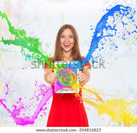 girl happy smile hold tablet screen with splash colorful paint, young woman wear red dress