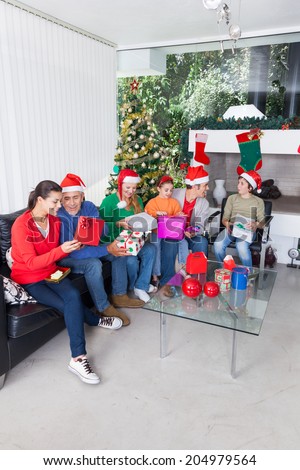 Family open gift box christmas holiday parents, senior grandparents and children give present sitting on sofa living room