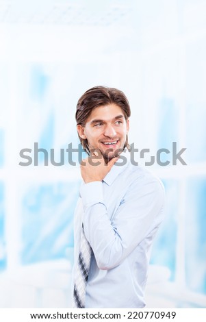 Handsome young business man smile look side to empty copy space, businessman ponder, idea, hold hand finger on chin wear blue shirt