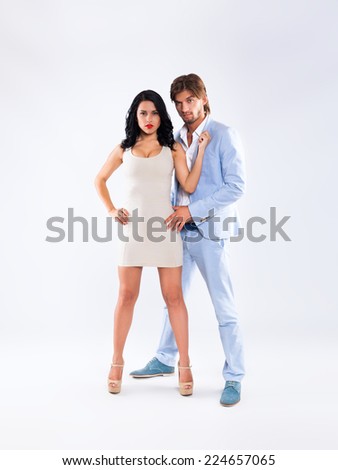 Fashion couple, men wear blue suit and woman sexy dress high heel shoes, full length over gray background
