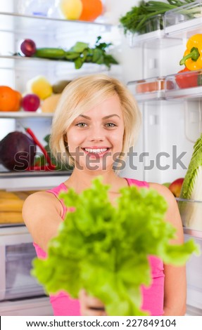young woman hold fresh green salad diet, refrigerator open door, pretty girl dieting healthy food vegetables and fruits