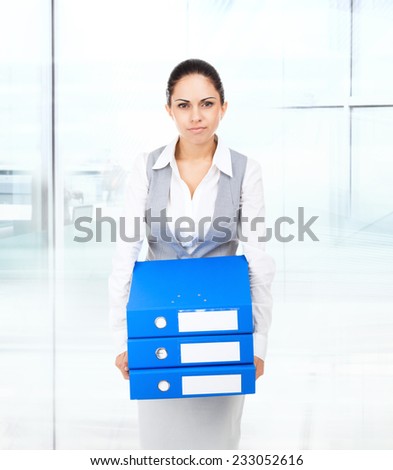 tired bored overworked business woman hold folder stack hands, looking sad at camera, young businesswoman workout concept work problem in modern office