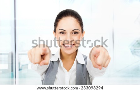 Business woman point finger at you looking at camera. businesswoman excited smile in modern office