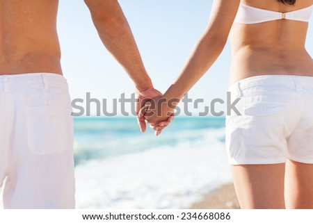 Summer couple holding hands ocean beach. Close up concept of romantic love on vacation holiday sea travel