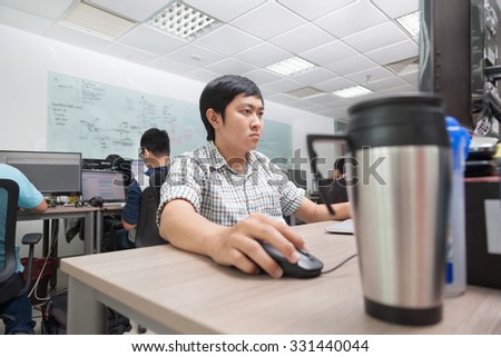 Asian Developer Using Laptop Computer Sitting Desk Working Real Office