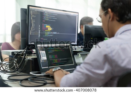 Asian Outsource Developer Looking Screen Sitting At Desk Working Laptop Computer Mobile Application Software Real Office