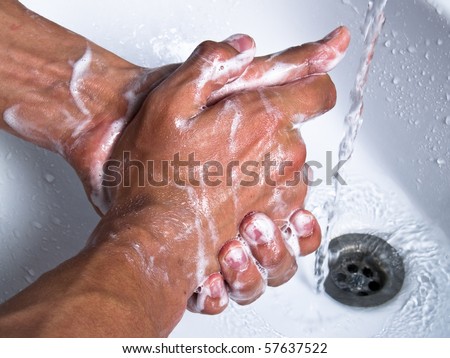 Man washing soapy hands in bathroom