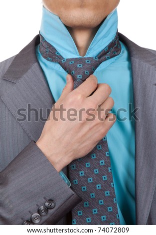 closeup businessman suit in a suit straightens his tie isolated over white background