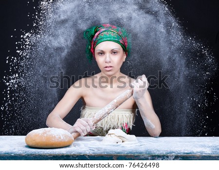 beautiful attractive girl sitting at the table and mix dough, kneading pizza ( bread ), cook concept.