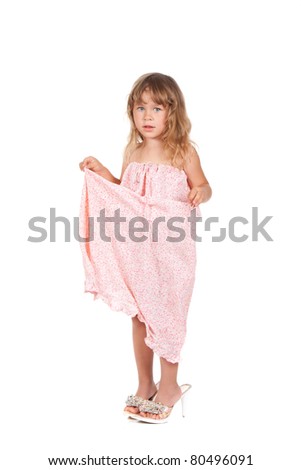 Posing young little caucasian girl wearing mothers big size shoes and dress isolated on white background
