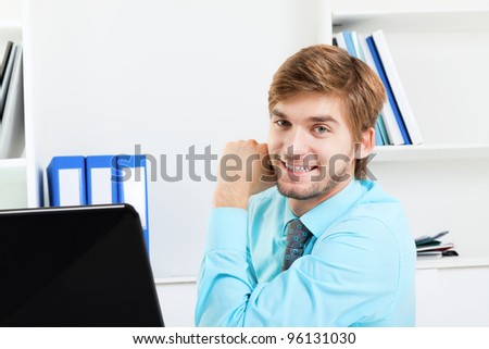 businessman happy smile sitting at the desk in office, handsome young business man wear blue shirt.