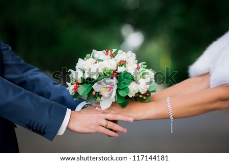 Beautiful wedding bouquet in brides and grooms hands