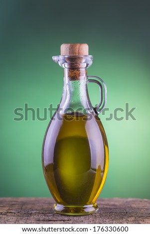 Olive oil  bottle made of glass with a green light spotlight background