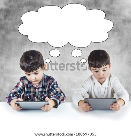 Twin brothers connected by wireless and playing with a digital tablet.