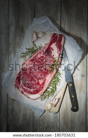 Fresh uncooked steak on a wooden background